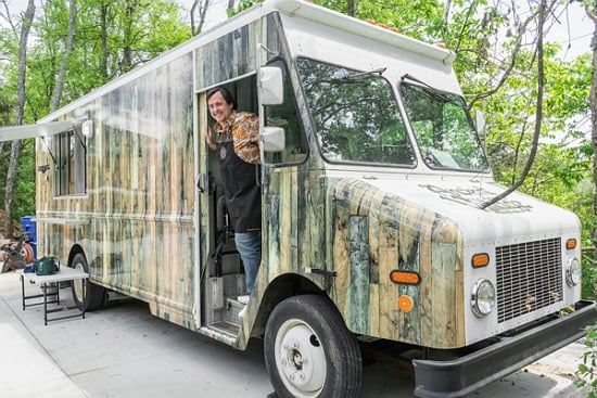 Chef Simon Hall stands in the Ancient Lore Village food truck